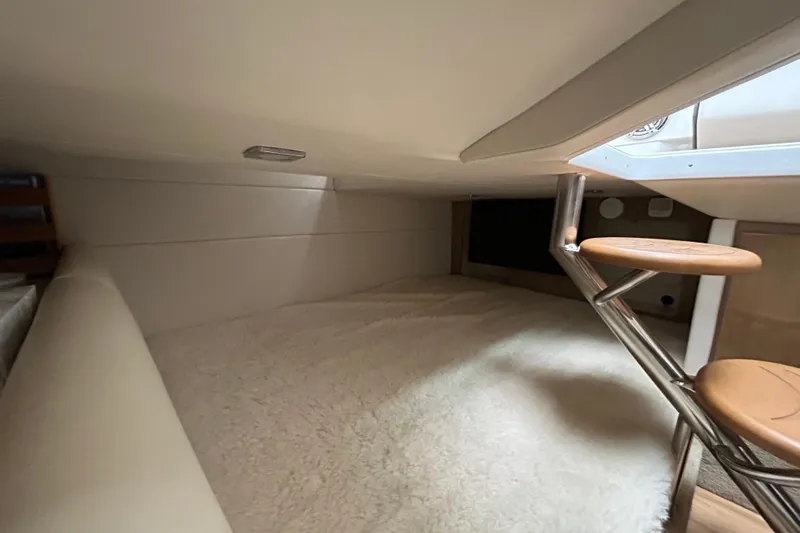 Slide: The Image of 2017 Formula 350 Crossover Bowrider cabin interior with cozy bedding and wooden steps. - 13