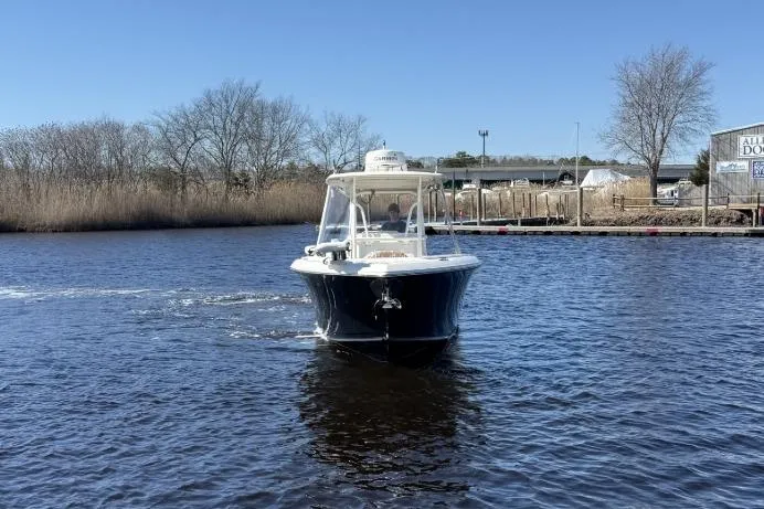 The Image of 2015 Sailfish 2860 CC boat cruising on a calm river under a clear blue sky. - 0