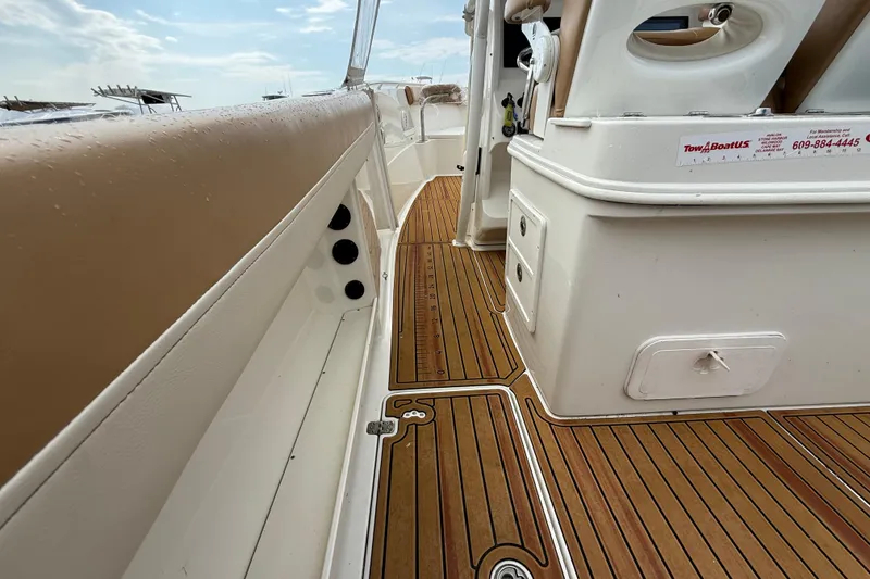 Slide: The Image of 2015 Sailfish 2860 CC boat interior with teak flooring and cushioned seating. - 4