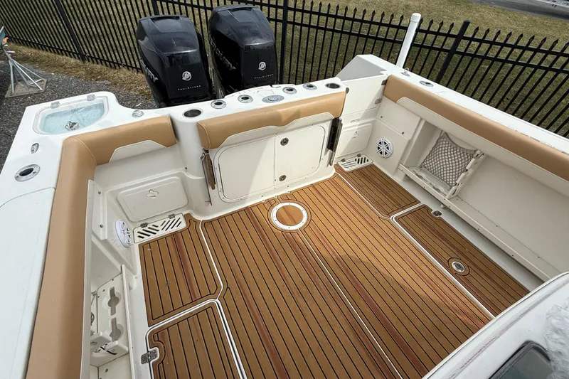 Slide: The Image of 2015 Sailfish 2860 CC boat interior with teak flooring and dual Mercury engines. - 7