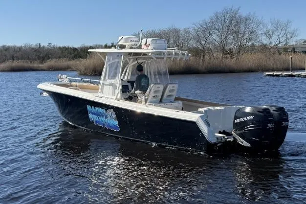 Slide: The Image of 2015 Sailfish 2860 CC boat on water with Mercury engines, clear sky background. - 8