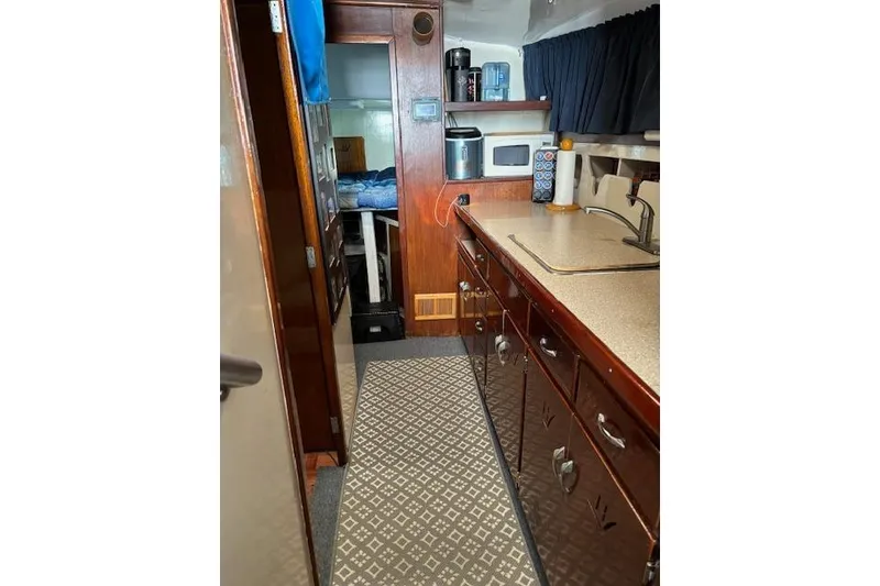Slide: The Image of Interior of a 1961 Hatteras 41 Convertible yacht with wooden cabinetry and kitchenette. - 3