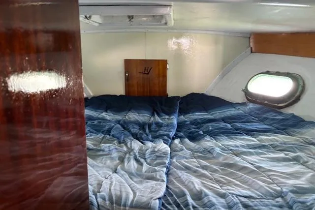Slide: The Image of Interior cabin of 1961 Hatteras 41 Convertible with cozy bedding and porthole window. - 4