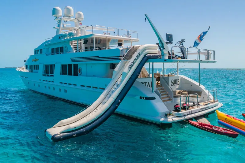 Slide: The Image of Luxurious 1988 Van Mill Custom yacht with waterslide and kayaks in clear blue ocean. - 104