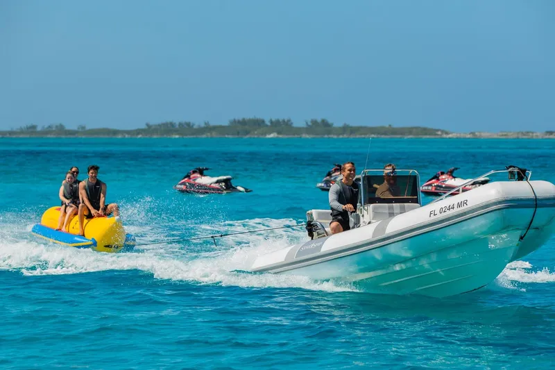 Slide: The Image of Boat towing banana boat with riders on clear blue water, Van Mill Custom 1988. - 111