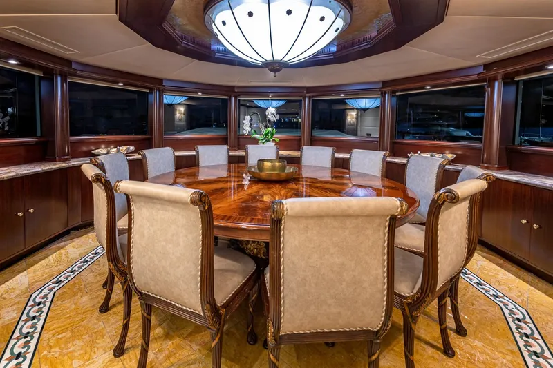 Slide: The Image of Luxurious yacht dining room with elegant wood table, plush chairs, and ambient lighting, Van Mill 1988. - 45