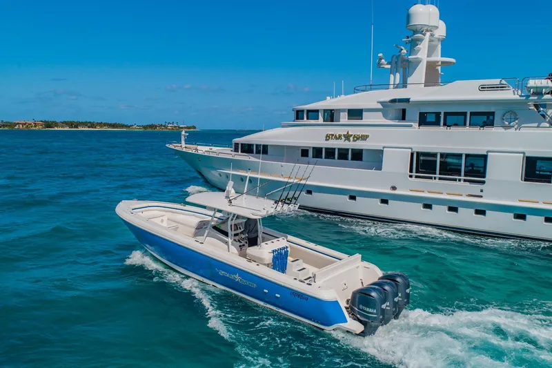 Slide: The Image of A 1988 Van Mill Custom yacht cruising alongside a smaller blue and white boat in clear waters. - 7