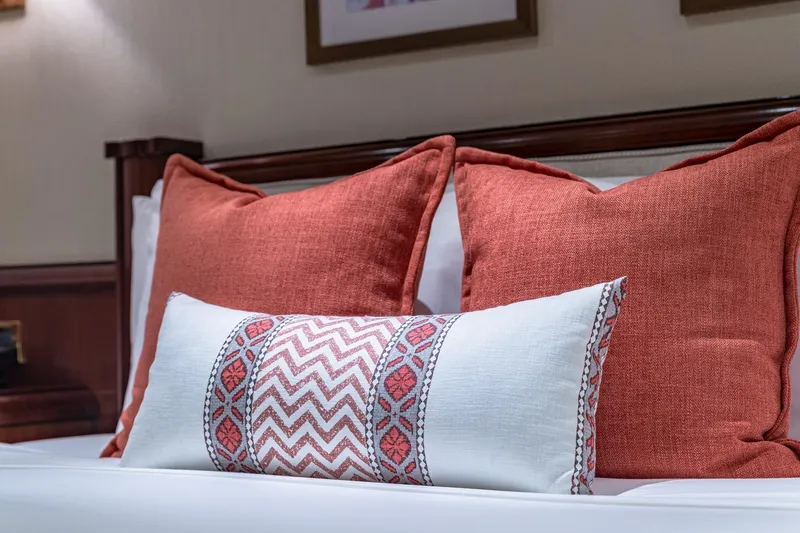 Slide: The Image of Decorative pillows on a bed with red and white patterns, Van Mill Custom 1988. - 79
