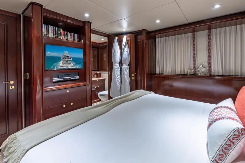 Slide: The Image of Luxurious 1988 Van Mill Custom yacht bedroom with TV, elegant wood paneling, and cozy bedding. - 80