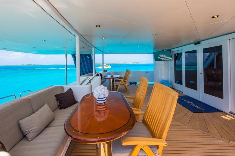 Slide: The Image of Luxurious 1988 Van Mill Custom yacht deck with ocean view, elegant seating, and wooden table. - 95