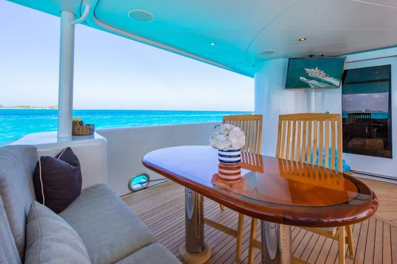 Slide: The Image of Luxurious yacht deck with wooden table, chairs, and ocean view; Van Mill Custom 1988. - 97