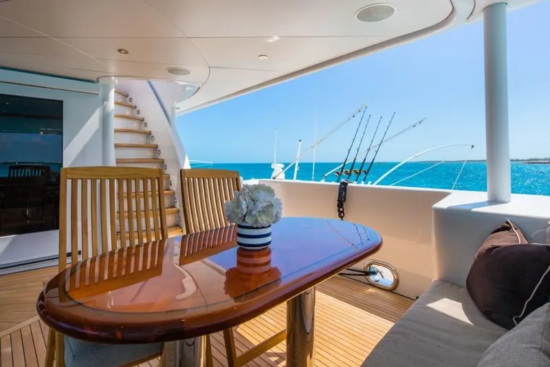 Slide: The Image of Luxurious 1988 Van Mill Custom yacht deck with ocean view, wooden table, and fishing rods. - 98