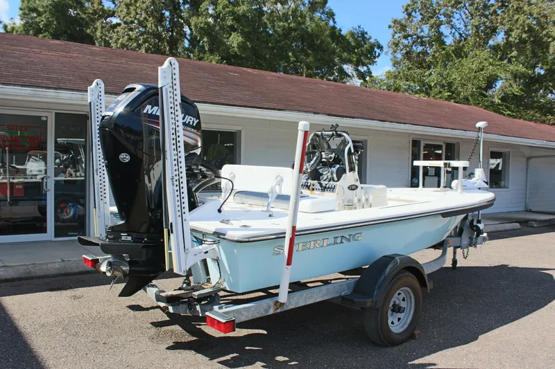 Slide: The Image of 2017 Sterling TR7 boat on trailer with Mercury engine, parked outside a building. - 9