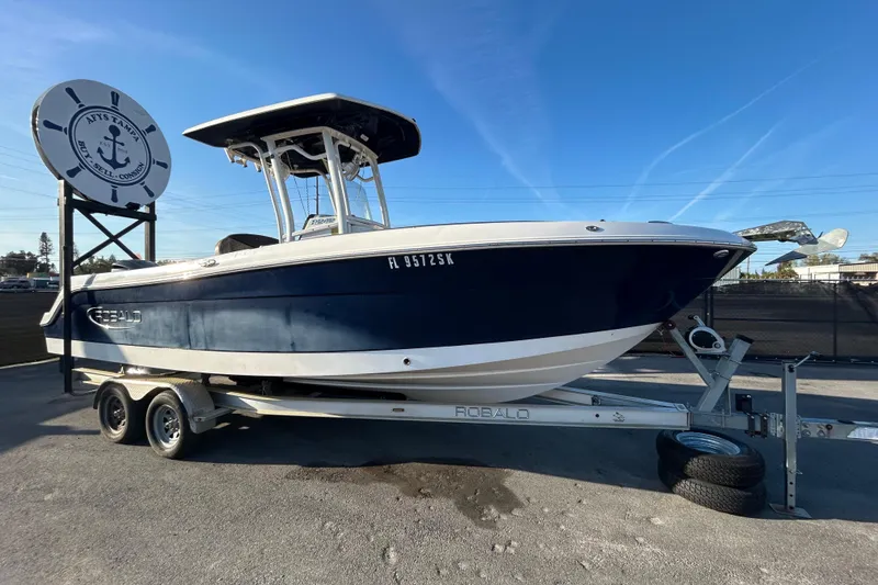 The Image of 2019 Robalo R242 Explorer boat on trailer under clear blue sky. - 0