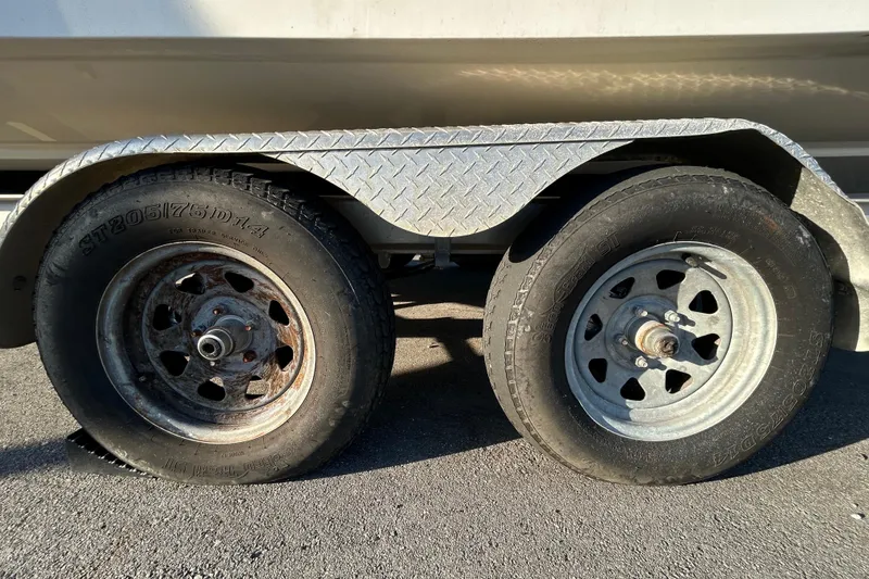 Slide: The Image of 2019 Robalo R242 Explorer boat interior with seating and console, parked outdoors. - 13