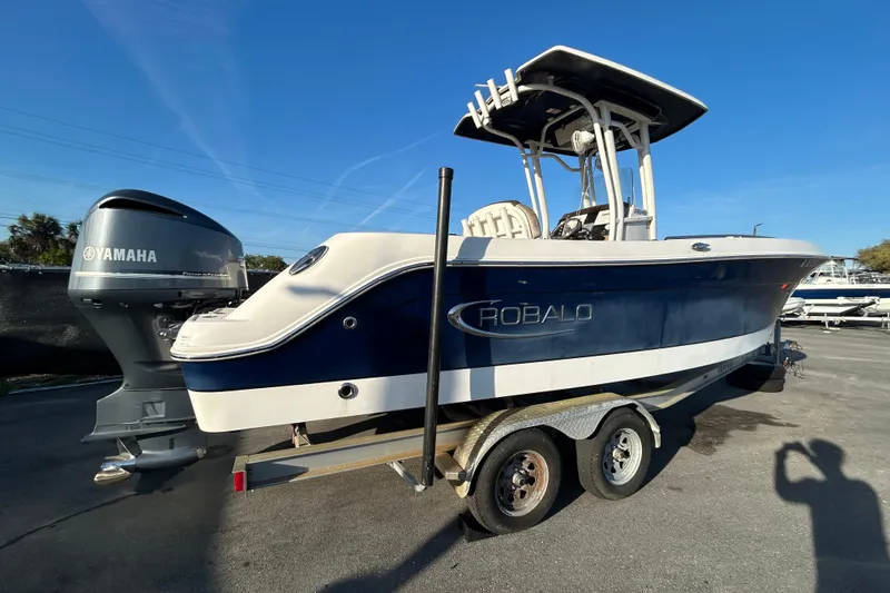 Slide: The Image of 2019 Robalo R242 Explorer boat with Yamaha engine on trailer under blue sky. - 2