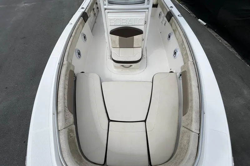 Slide: The Image of 2019 Robalo R242 Explorer boat interior with cushioned seating and speakers. - 27