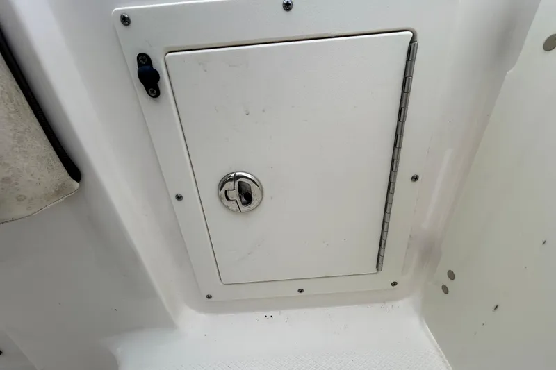 Slide: The Image of 2019 Robalo R242 Explorer storage compartment with secure latch and hinge. - 37