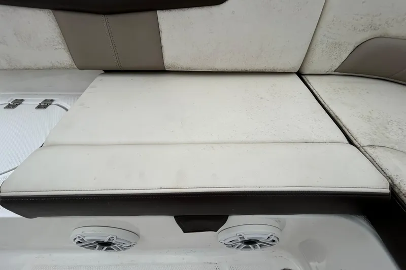 Slide: The Image of Robalo R242 Explorer 2019 boat seating with white upholstery and speaker detail. - 44
