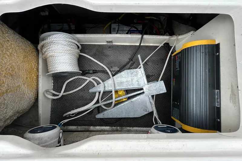 Slide: The Image of Storage compartment of 2019 Robalo R242 Explorer with anchor, rope, and battery charger. - 47