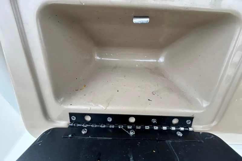 Slide: The Image of Storage compartment of a 2019 Robalo R242 Explorer boat, featuring a hinged lid. - 60