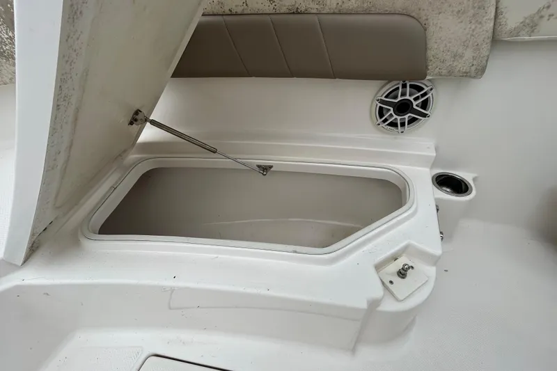 Slide: The Image of Open storage compartment on 2019 Robalo R242 Explorer boat with speaker and cup holder. - 68