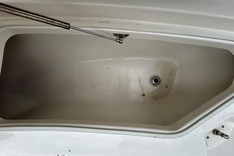 Slide: The Image of Storage compartment of a 2019 Robalo R242 Explorer boat, featuring a drain plug. - 69