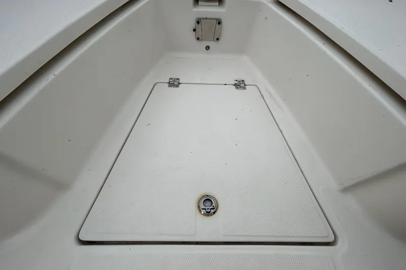 Slide: The Image of 2019 Robalo R242 Explorer boat storage compartment with secure latch and clean interior. - 79
