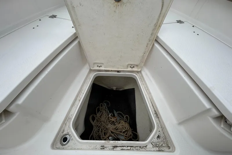 Slide: The Image of Open storage compartment on 2019 Robalo R242 Explorer boat with rope inside. - 80