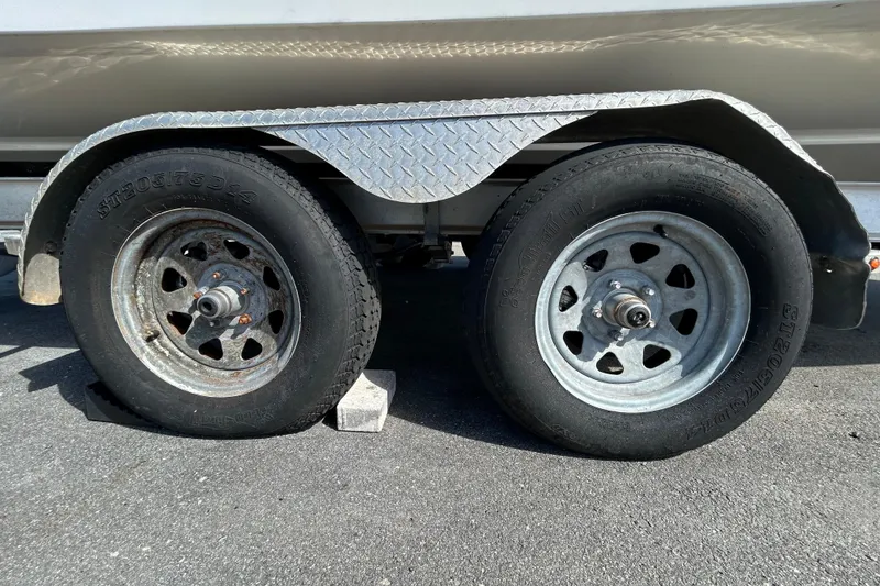 Slide: The Image of Trailer wheels of a 2019 Robalo R242 Explorer boat on pavement. - 89