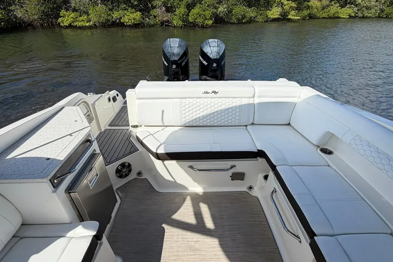 Slide: The Image of 2020 Sea Ray SDX 290 Outboard boat interior with white seating and dual engines. - 14