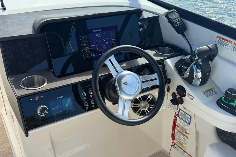 Slide: The Image of 2020 Sea Ray SDX 290 Outboard helm with steering wheel, controls, and navigation display. - 16