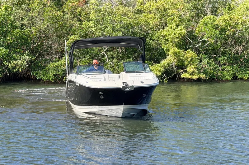 Slide: The Image of 2020 Sea Ray SDX 290 Outboard cruising on a calm river with lush greenery. - 3