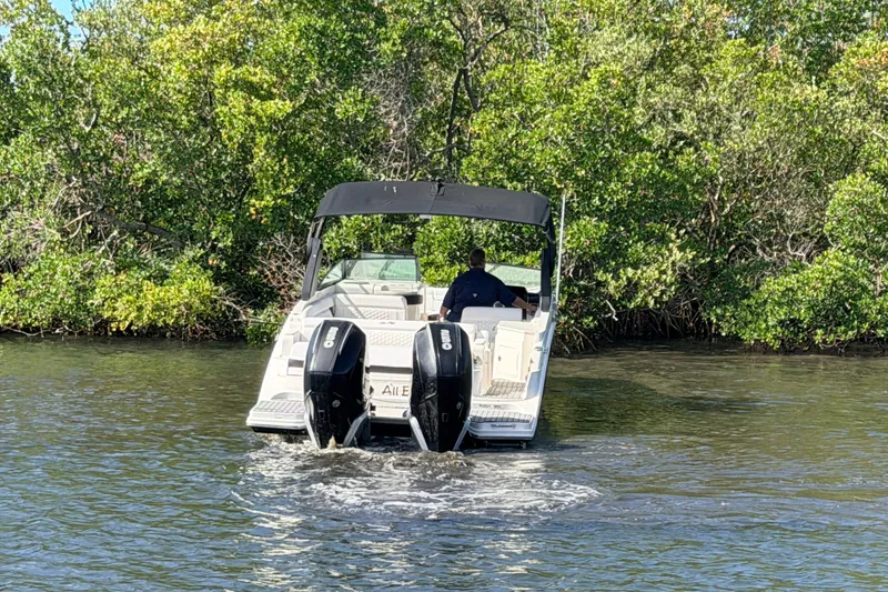 Slide: The Image of 2020 Sea Ray SDX 290 Outboard navigating through lush green waters. - 5