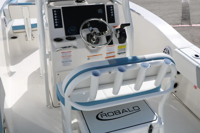 Slide: The Image of 2026 Robalo R200 Center Console boat interior with steering wheel and rod holders. - 18