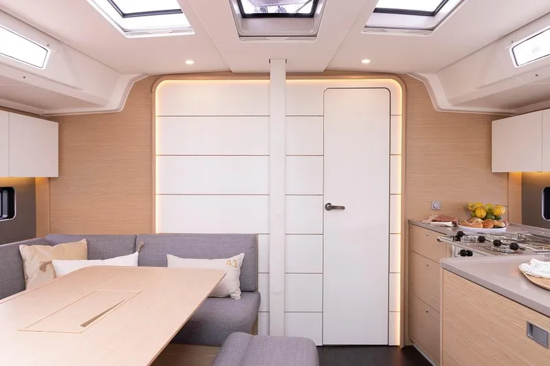 Slide: The Image of Modern interior of 2024 Dufour 41 yacht with skylights, dining area, and kitchen. - 11