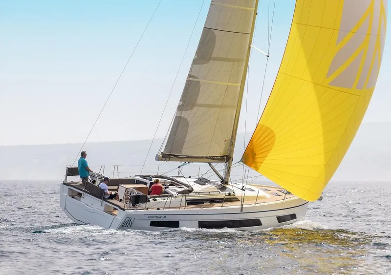 Slide: The Image of 2024 Dufour 41 sailboat with yellow sail cruising on open water. - 9