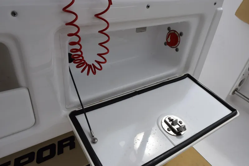 Slide: The Image of 2019 Sportsman Heritage 211 Center Console storage compartment with red coiled safety lanyard. - 20