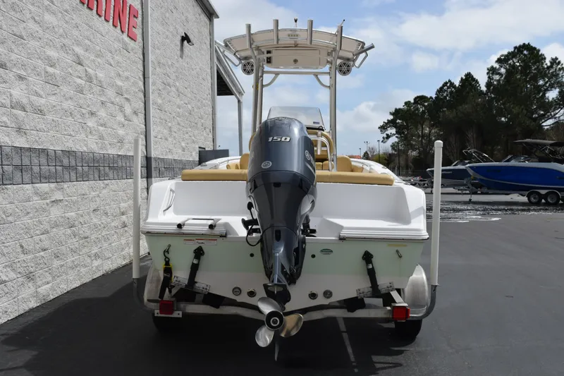 Slide: The Image of 2019 Sportsman Heritage 211 Center Console boat with outboard motor, parked outdoors. - 5