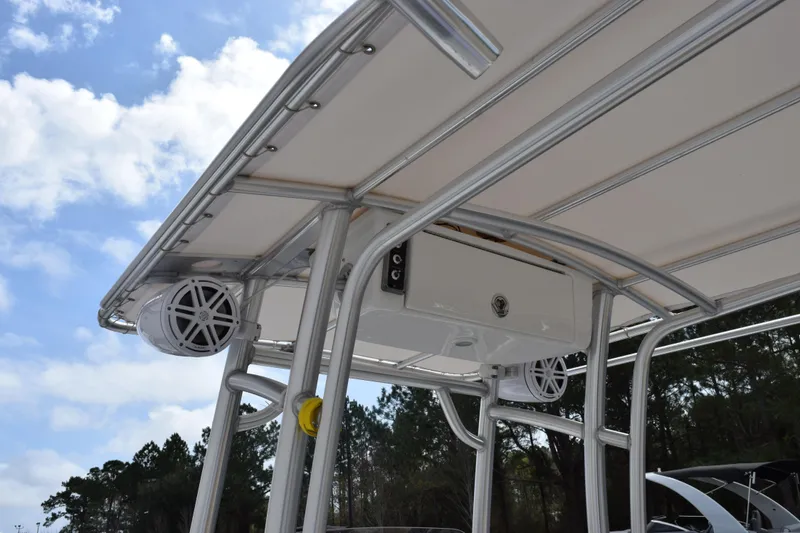 Slide: The Image of 2019 Sportsman Heritage 211 Center Console boat with T-top and speakers under a blue sky. - 8