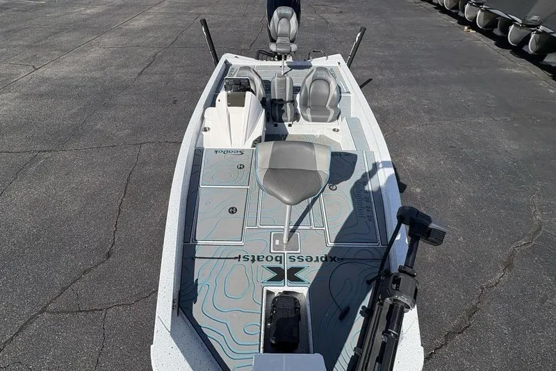 Slide: The Image of 2022 Xpress X19 Pro fishing boat with seating and storage on a paved surface. - 31