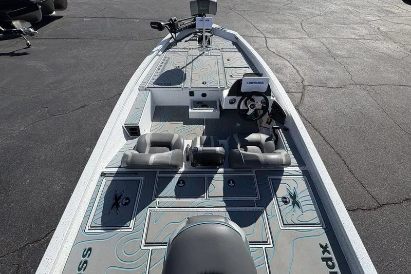 Slide: The Image of 2022 Xpress X19 Pro boat interior with steering console and seating on a paved surface. - 32