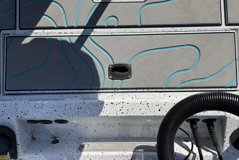 Slide: The Image of 2022 Xpress X19 Pro boat deck with textured surface and storage compartment. - 36