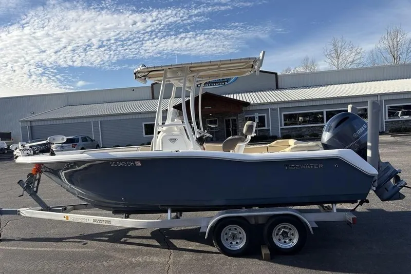 The Image of 2018 Tidewater 210 LXF boat on trailer, parked outside a building under a blue sky. - 1