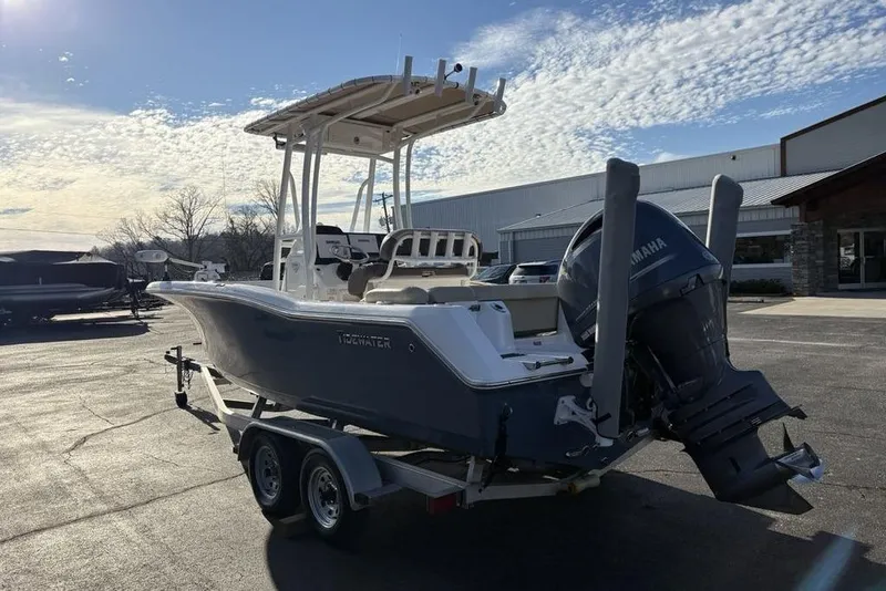 Slide: The Image of 2018 Tidewater 210 LXF boat on trailer, parked outdoors under a partly cloudy sky. - 10