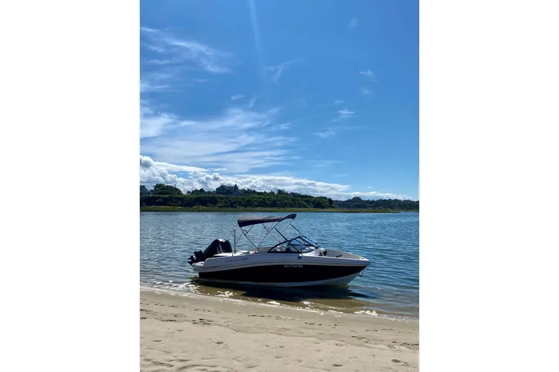 Slide: The Image of 2016 Tahoe 450 TS boat on a sunny beach with clear blue skies. - 10