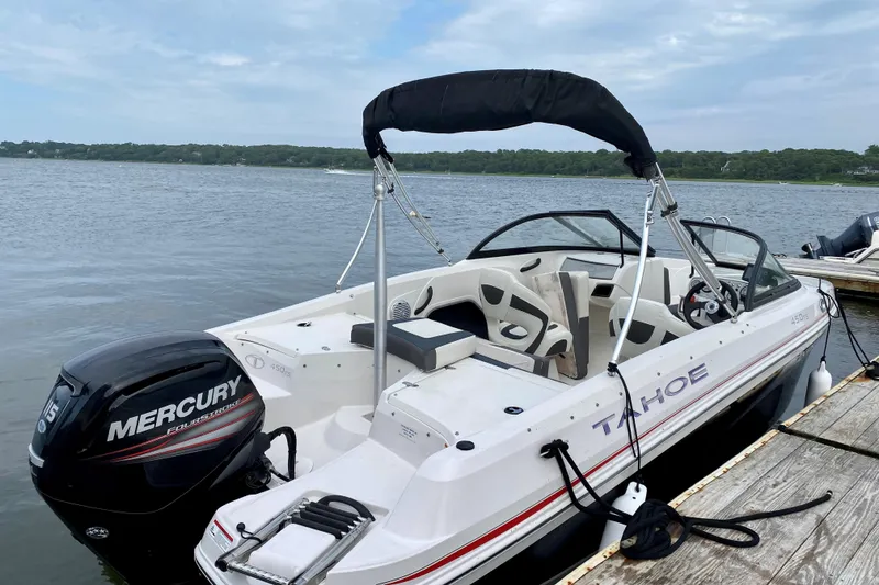 Slide: The Image of 2016 Tahoe 450 TS boat docked with Mercury outboard motor. - 3