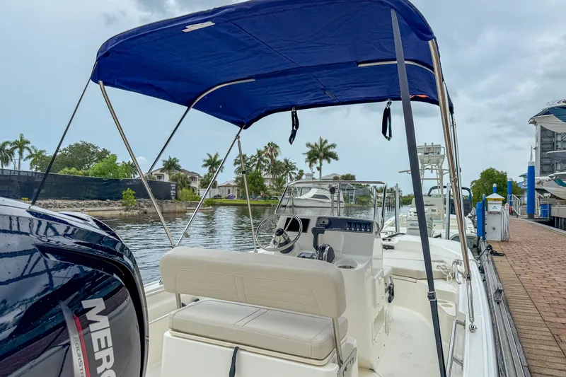 Slide: The Image of 2026 Boston Whaler 170 Montauk at dock with blue canopy. - 5