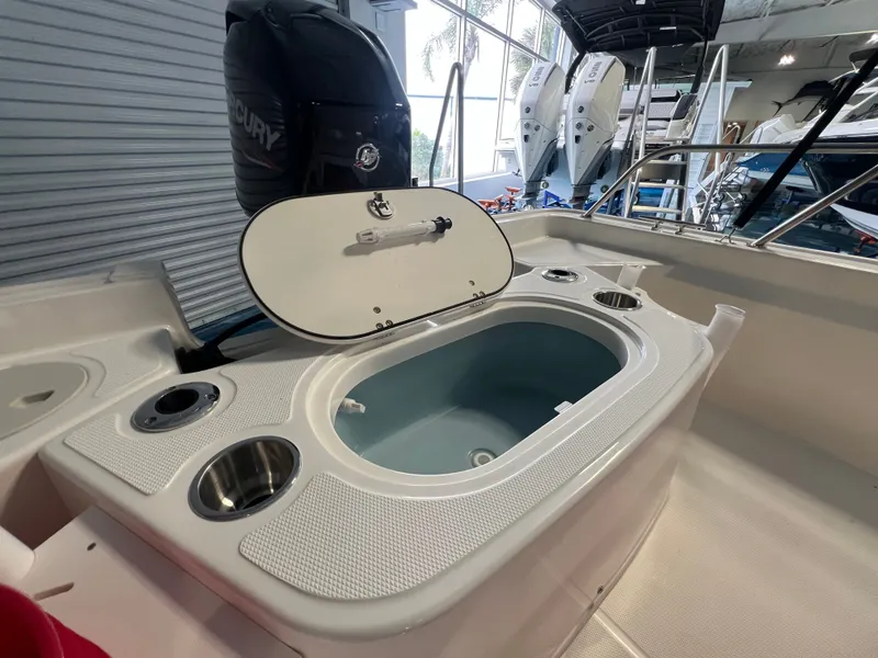 Slide: The Image of Boston Whaler 150 Montauk 2026 with open storage compartment and motor. - 16