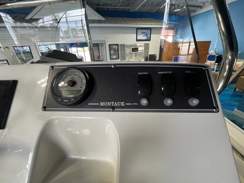 Slide: The Image of Dashboard of 2026 Boston Whaler 150 Montauk with switches and tachometer. - 19
